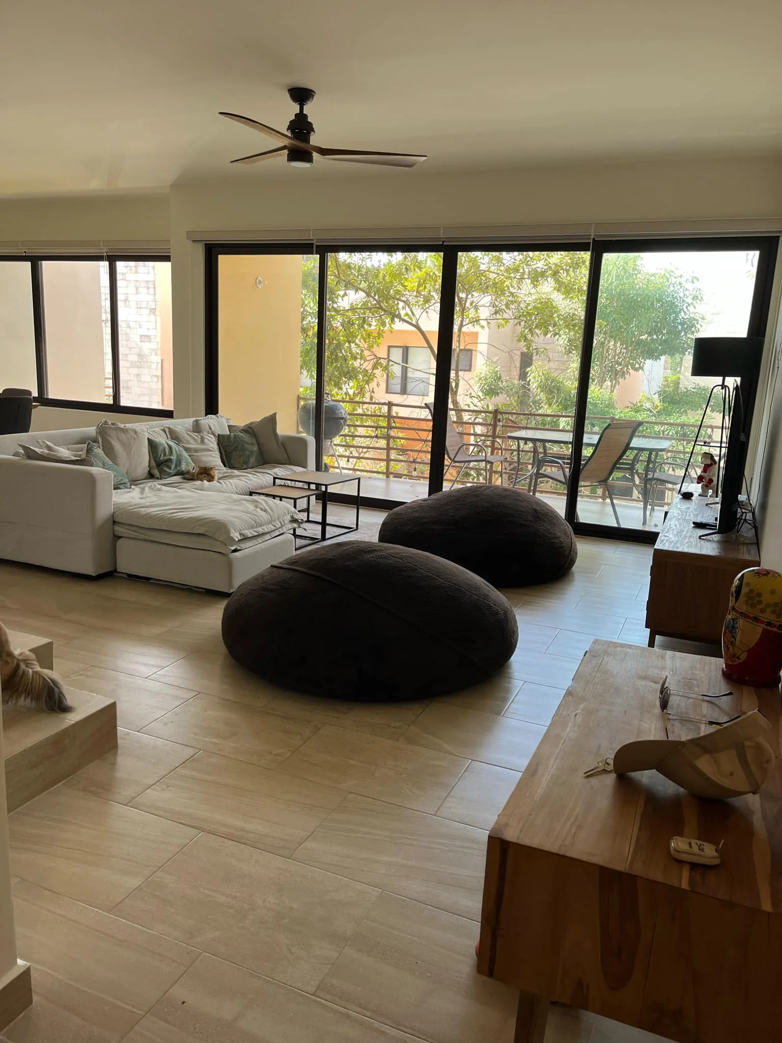 Sala luminosa con grandes ventanales y acceso a la terraza